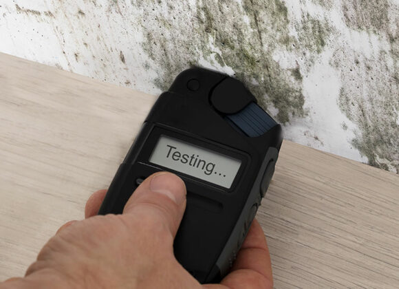 Hand Holding Device Against Wall for LEED Indoor Air Quality Assessment in Washington, DC